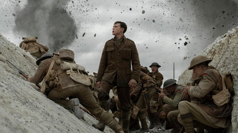 George MacKay, center stars in "1917," co-written and directed by Sam...