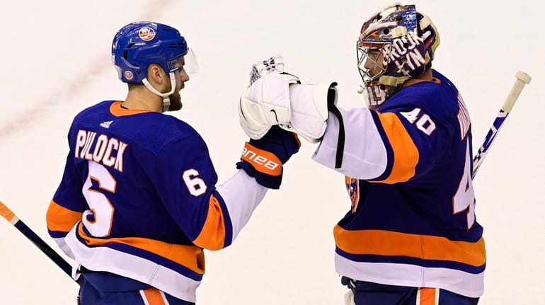 Islanders defenseman Ryan Pulock celebrates with goaltender Semyon Varlamov after defeating...