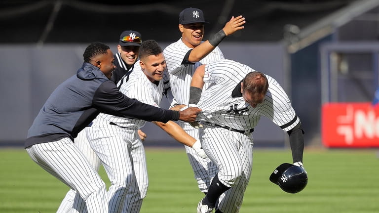 Yankees catcher Austin Romine (28) gets congratulations from teammates after...