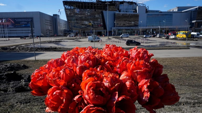 Flowers lie in front of the Crocus City Hall on...