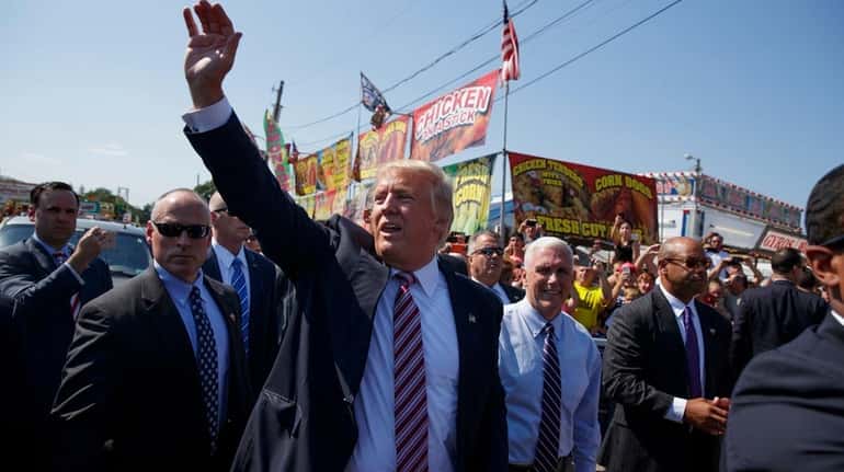 Republican presidential candidate Donald Trump waves as he walks with...