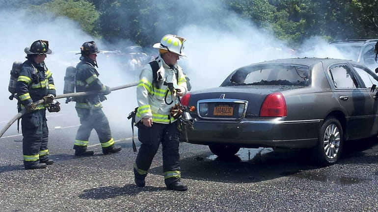 Firefighters extinguish a car fire that took place in the...