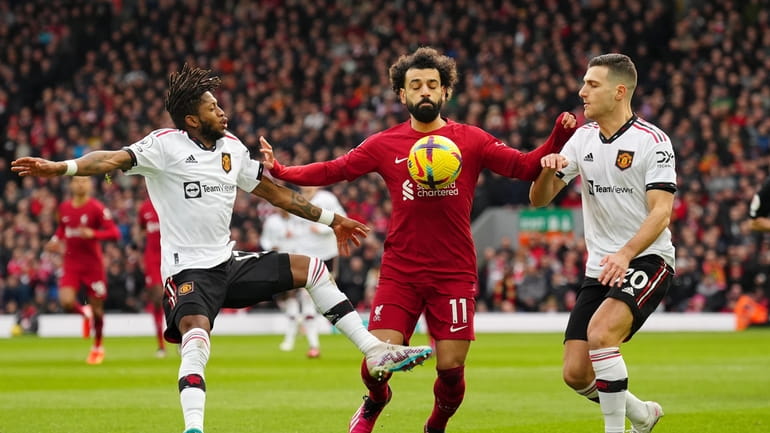 Liverpool's Mohamed Salah, centre, tries to hold off Manchester United's...