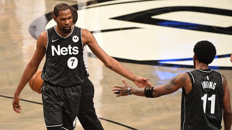 Nets forward Kevin Durant and guard Kyrie Irving react during...