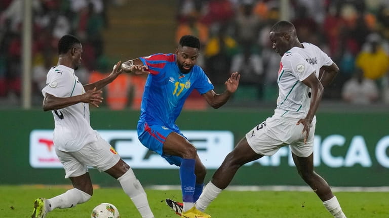 DR Congo's Cedric Bakambu, center, duels for the ball with...