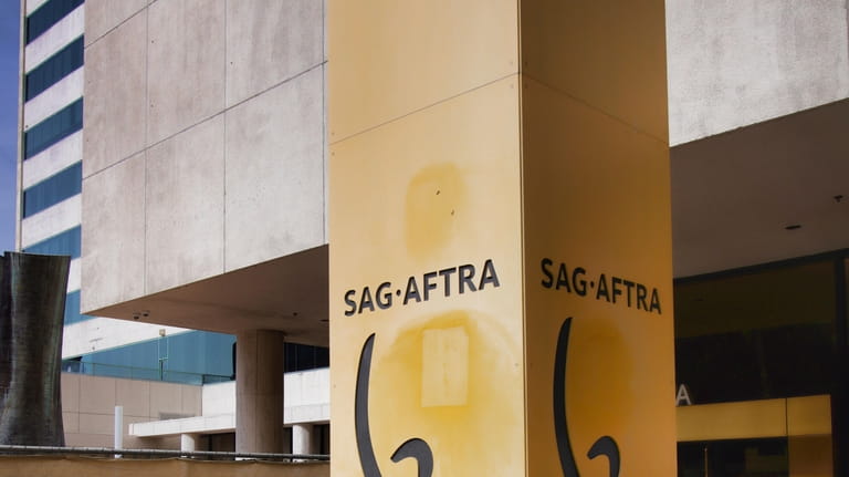 A pedestrian steps into the entrance of SAG-AFTRA offices in...
