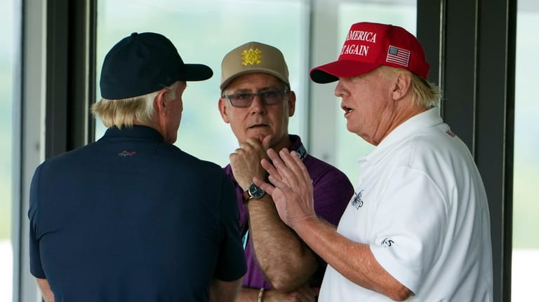 Former President Donald Trump talks with Greg Norman, LIV Golf...