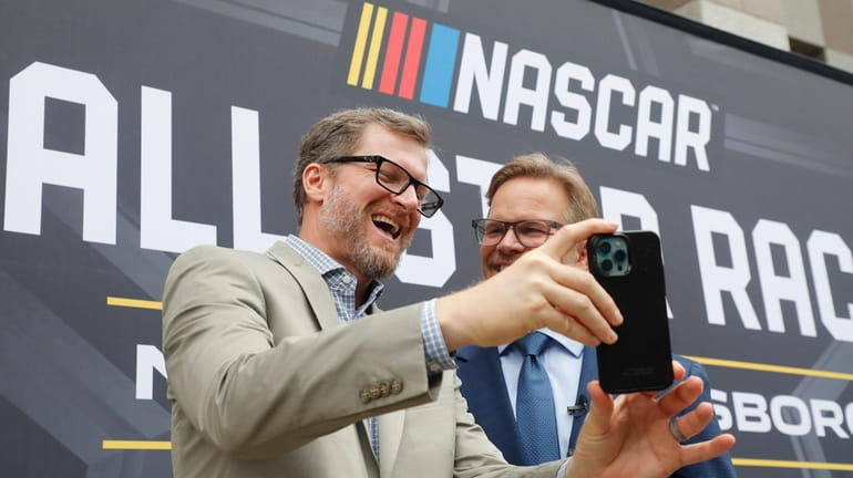 Dale Earnhardt Jr., left, laughs with Speedway Motorsports President and...