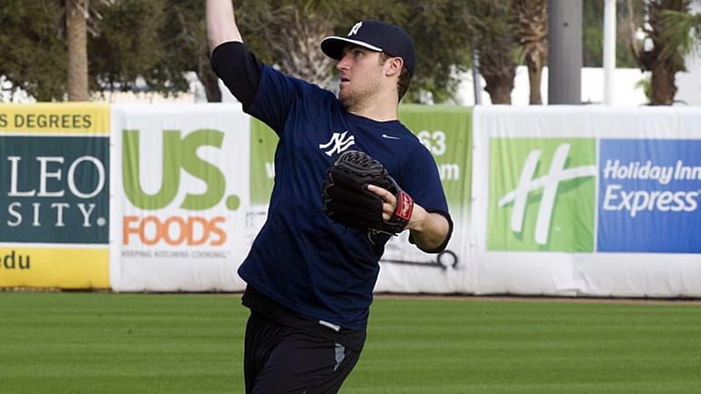 Yankees pitcher Phil Hughes warms up his arm at George...