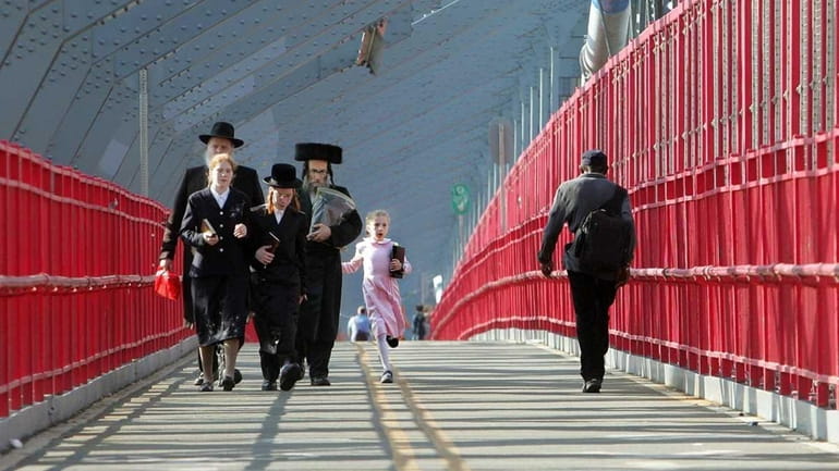 Hasidic Satmar Jews walk across the Williamsburg Bridge in Brooklyn.