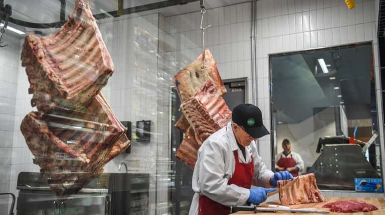 Richard Luchese prepares a cut of beef at Whole Foods...