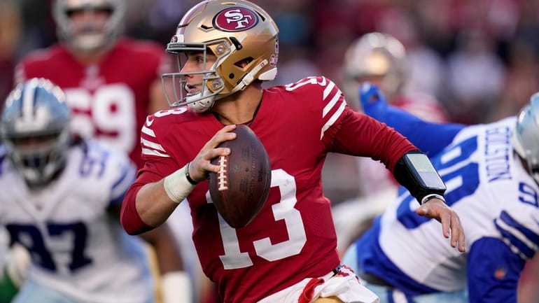 San Francisco 49ers quarterback Brock Purdy (13) rolls out against...