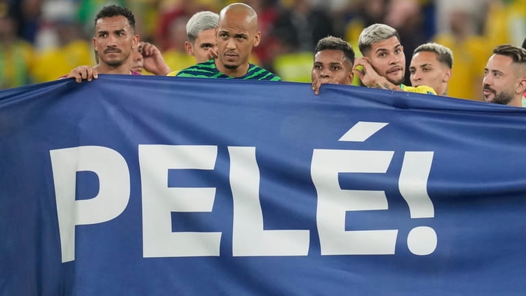 Brazilian players hold a banner in honour of the 82-year-old...