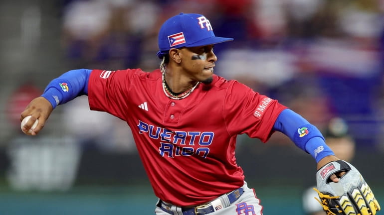 Francisco Lindor #12 of Team Puerto Rico throws to first...