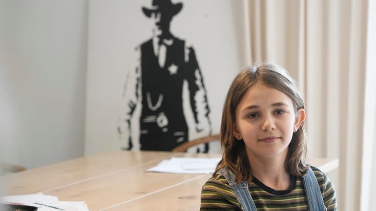 Ola Kozak, 11, sits at the table where she used...