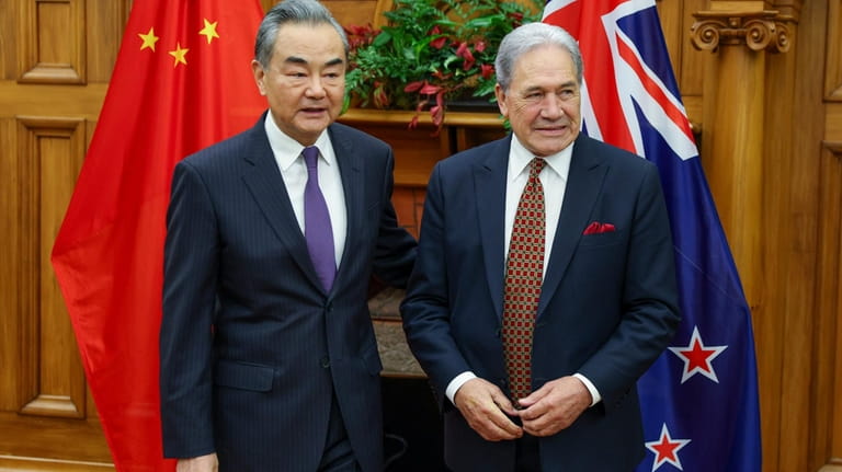 China's Minister of Foreign Affairs Wang Yi, left, meets his...