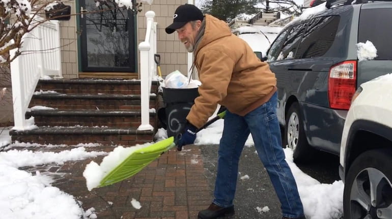 John Glasgow shovels his driveway in Hicksville on Monday morning.