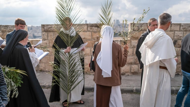 Christians walk in the Palm Sunday procession on the Mount...