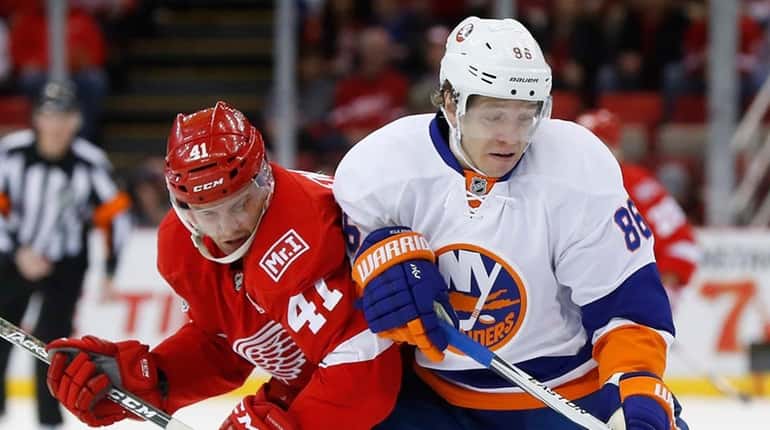 New York Islanders left wing Nikolay Kulemin (86) protects the...