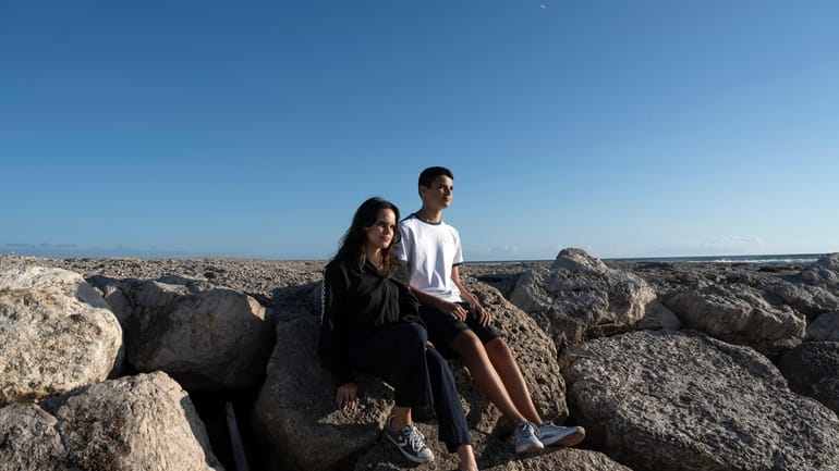Siblings Sofia Oliveira, 18, and Andre Oliveira, 15, pose for...