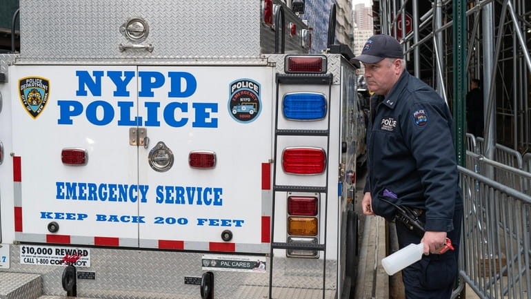 An NYPD ESU officer takes a spray bottle from a...
