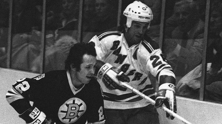 The Bruins' Brad Park, left, skates beside the Rangers Dave...