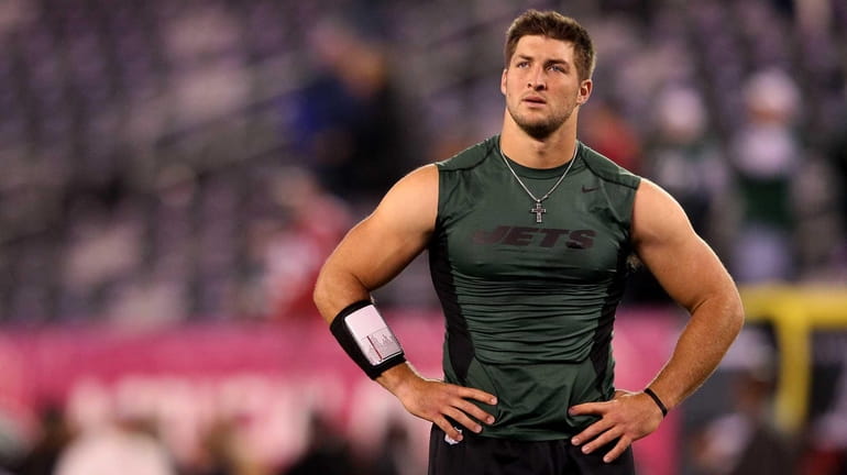 Tim Tebow looks on during warm-ups before a game against...