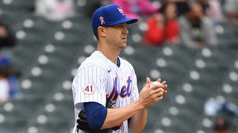 Mets starting pitcher Jacob deGrom reacts during the fifth inning...