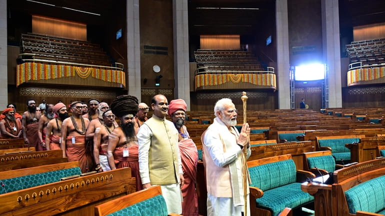 Indian prime minister Narendra Modi carries a royal golden sceptre...