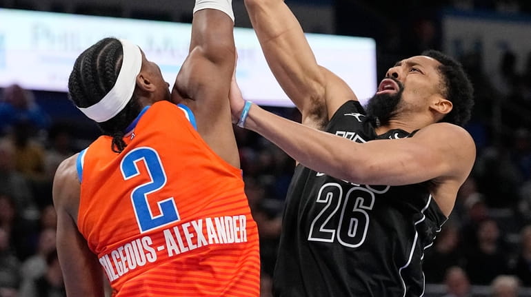 Nets guard Spencer Dinwiddie shoots as Thunder guard Shai Gilgeous-Alexander defends in...