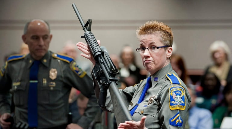 A Bushmaster AR-15 rifle is displayed by a Connecticut State Police...