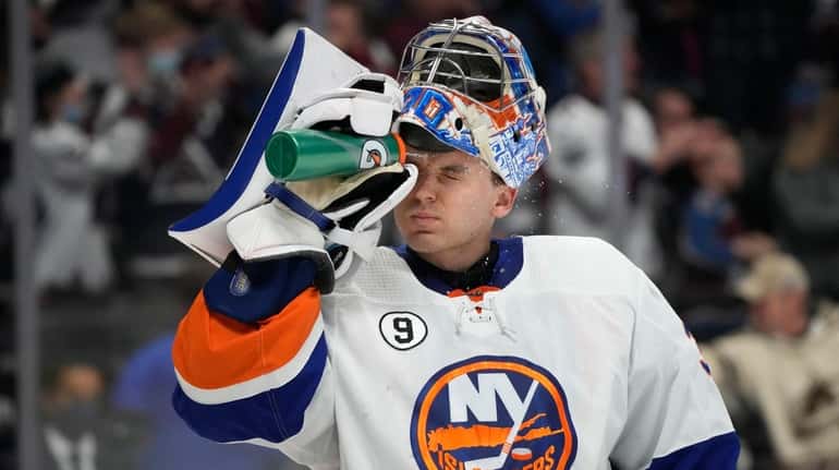 Islanders goaltender Ilya Sorokin sprays his face with water after...
