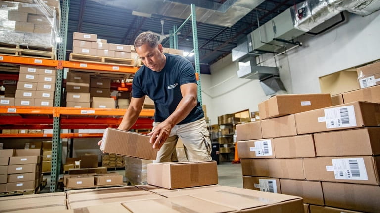 Warehouse associate Ivan Rosario places boxes onto pallets at NutraScience Labs...