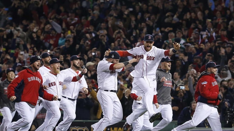 Boston Red Sox players run onto the field after defeating...