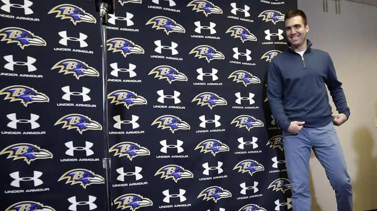 Baltimore Ravens quarterback Joe Flacco walks up to a microphone...