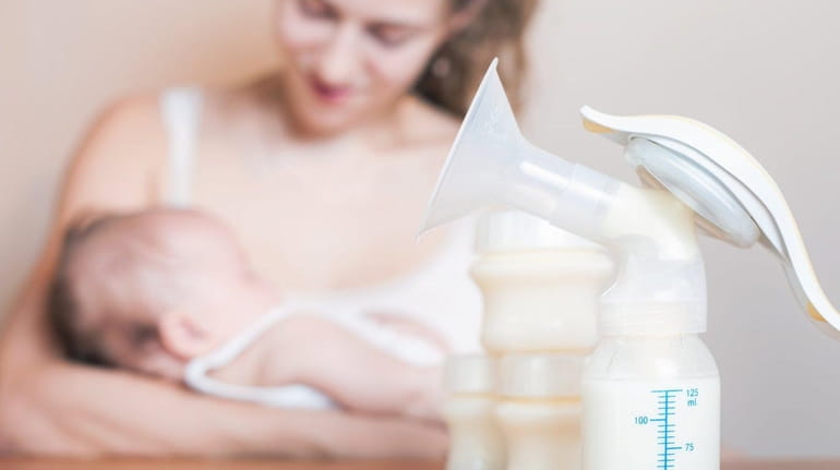 Manual breast pump and mother feeding at background, mothers breast...