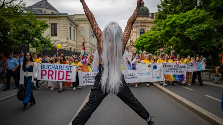 A participant jumps flashing victory signs during a pride parade...