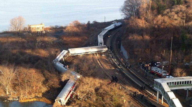 Cars of a Metro-North train that left the tracks in...