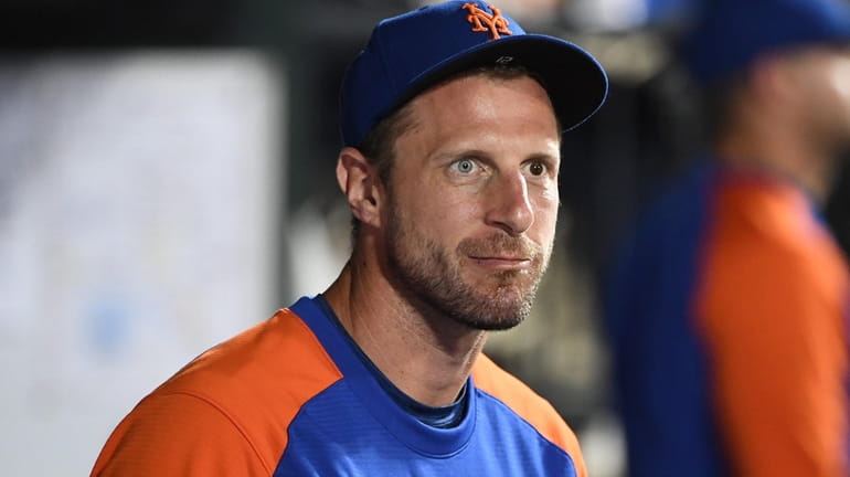 Mets starting pitcher Max Scherzer looks on from the dugout...