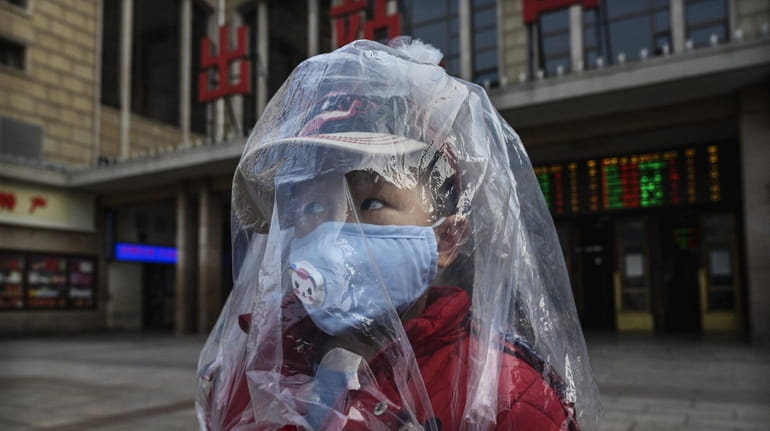 A Chinese boy is covered in a plastic bag for...