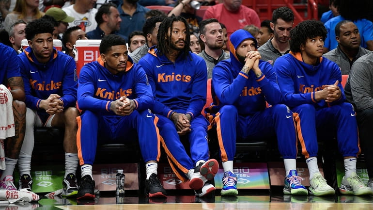 Knicks players watch their team fall behind the Heat during...