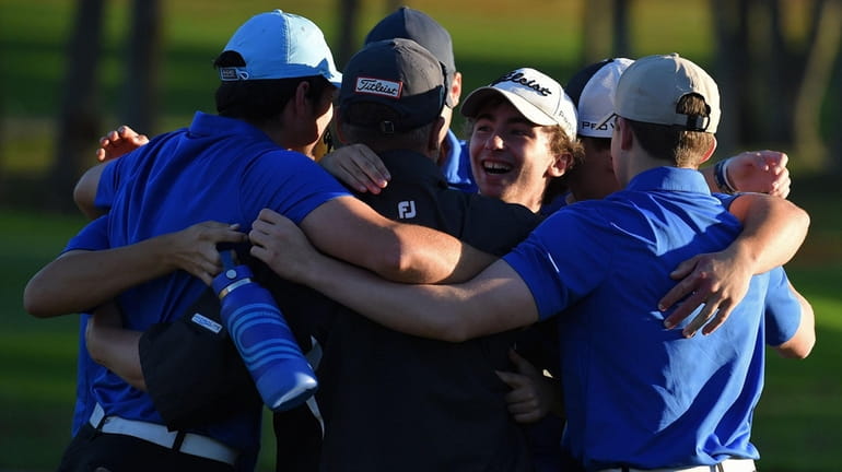 Patrick Brennan (facing) and teammates celebrate with Comsewogue-Miller Place coach...