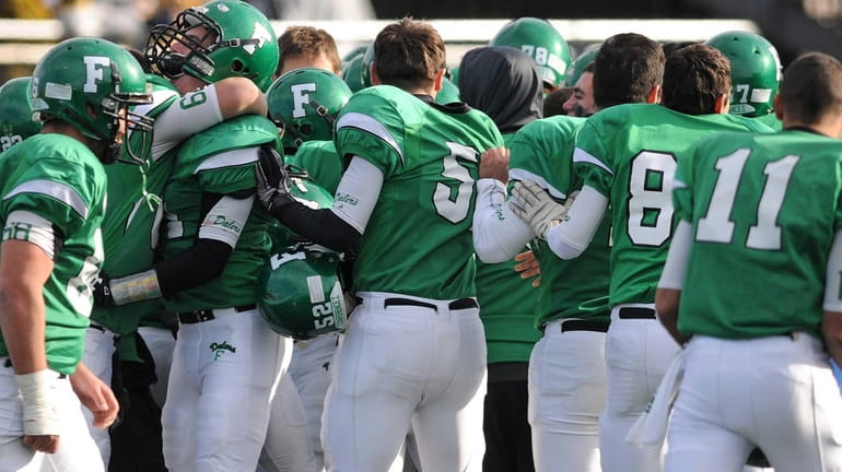 Farmingdale teammates celebrate after their 29-26 win over Massapequa in...