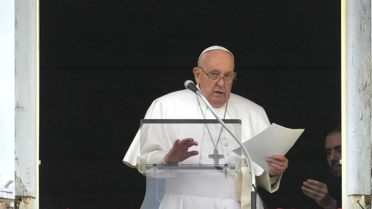 Pope Francis reads his message during the Angelus noon prayer...