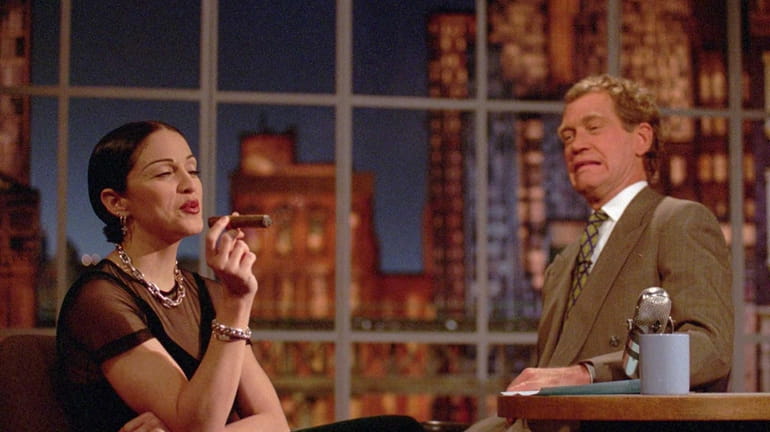 Madonna puffs on a cigar while David Letterman looks on...