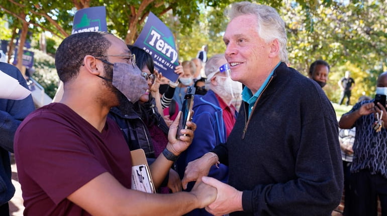 Former Gov. Terry McAuliffe, right, a Democrat, greets supporters during...