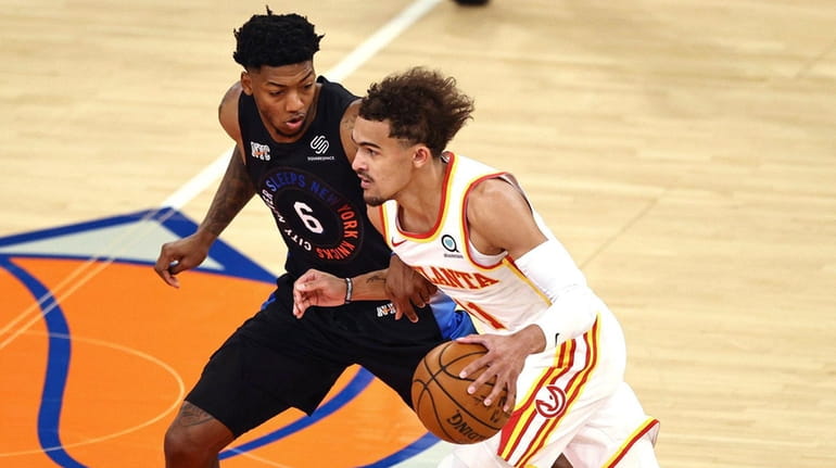 The Hawks' Trae Young tries to get past the Knicks'...