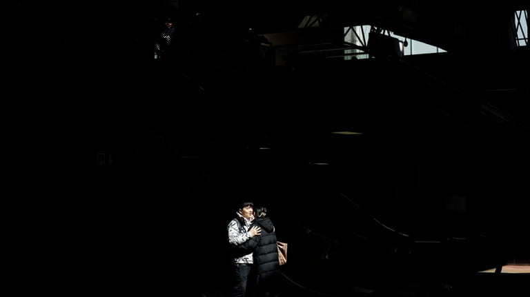 Passengers embrace at Atocha train station in Madrid, Spain on...
