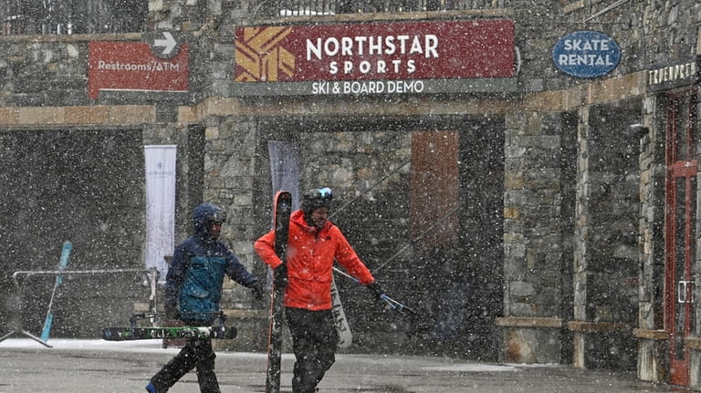 Skiers hurry along The Village at Northstar California Resort as...