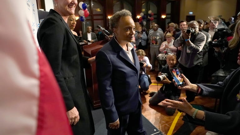 Chicago Mayor Lori Lightfoot, right, walks off the stage with...